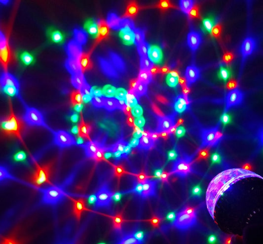 Colorful rotating magic ball lights creating vibrant RGB ambiance with swirling patterns in a dark background.